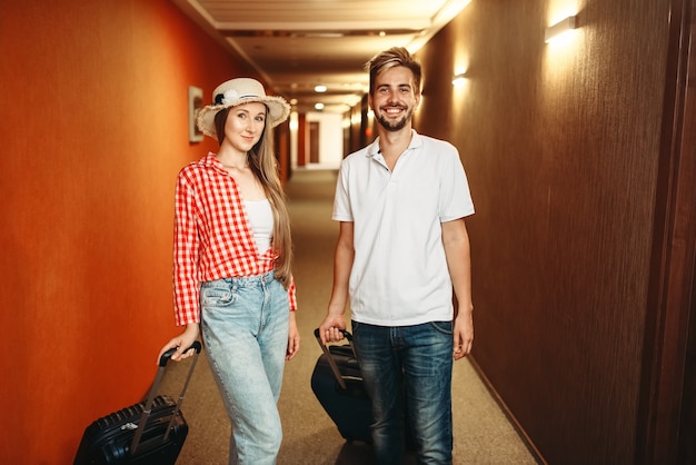 Coppia con le valigie il check-in in hotel