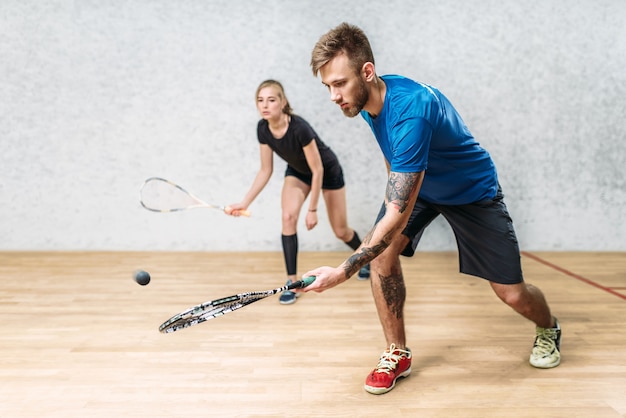 Coppia con racchette da squash, club di formazione indoor