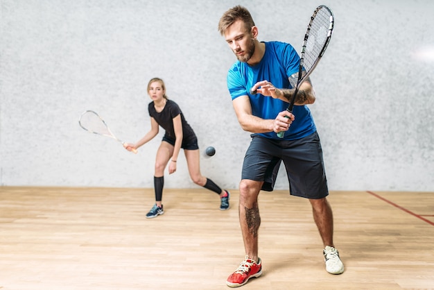 Coppia con racchette da squash, club di formazione indoor