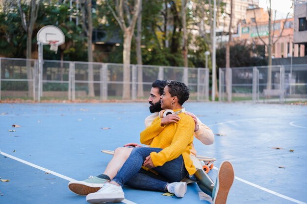 Coppia con ragazzo con gamba protesica insieme in uno spazio sportivo godendo del concetto di superamento dell'integrazione e dello sport