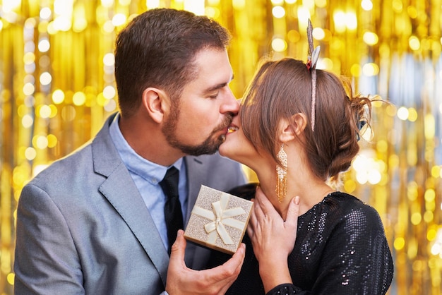 Coppia con regalo d'oro per capodanno o festa di Natale