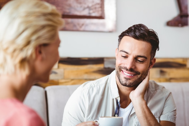 Coppia con tazza di caffè seduti sul divano