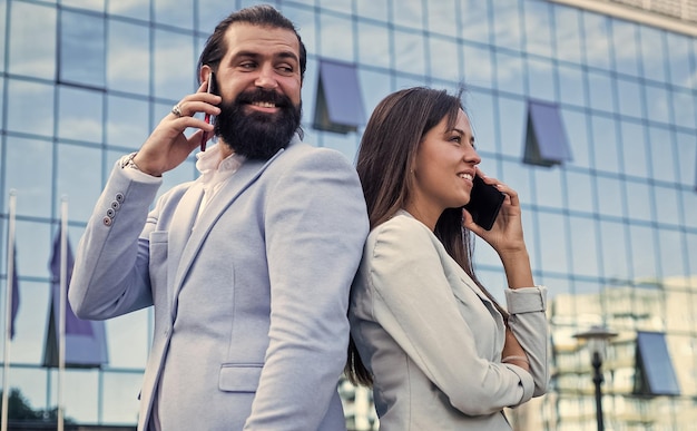 Coppia d'affari parlare al telefono uomo e donna per incontrare uomini d'affari amministratore delegato e dipendenti comunicazione aziendale uomo d'affari e assistente in abbigliamento formale capo con partnership donna