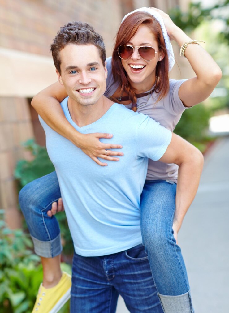 Foto coppia d'amore che ride e piggyback all'aperto per la connessione felicità e romanticismo estivo abbracciare l'uomo e portare la donna in città per il supporto di una relazione divertente e viaggiare con il partner in data insieme