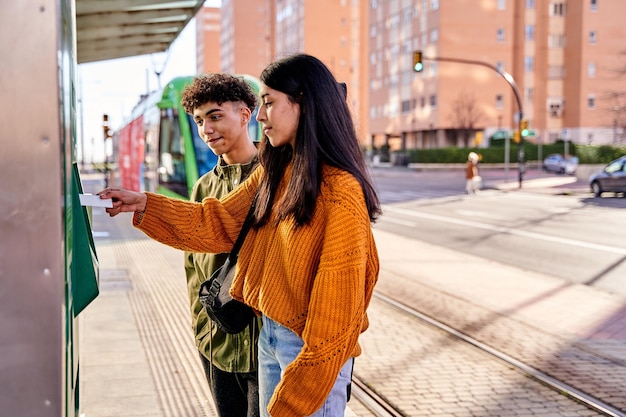 Coppia di adolescenti che acquistano i biglietti del tram con le loro carte di credito