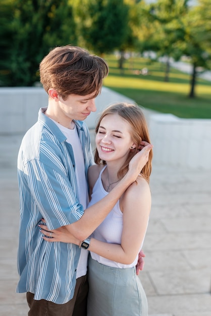Coppia di adolescenti che si tengono per mano e si abbracciano nel parco Il primo amore