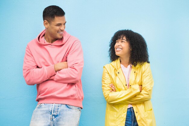 Coppia di amici felici e braccia incrociate su sfondo blu isolato in città supporto legame e divertimento viaggio in città Sorriso uomo felice o donna nera e fiducia capelli afro o mockup di vestiti di moda