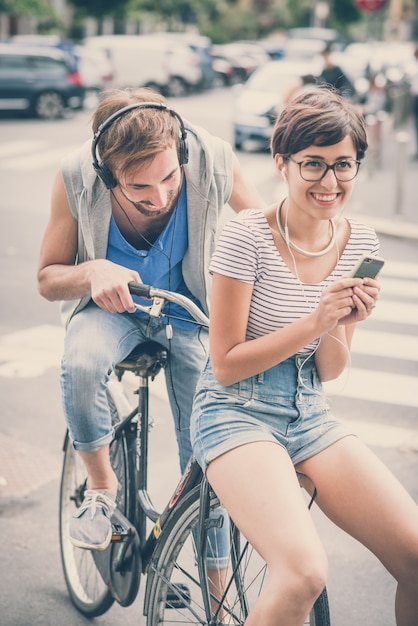 coppia di amici giovane uomo e donna in sella alla bici