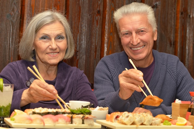 Coppia di anziani che mangia sushi in un bar