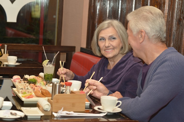 Coppia di anziani che mangia sushi in un bar