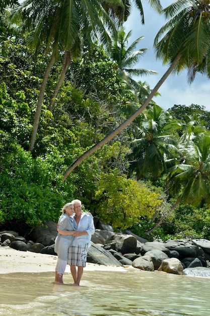 Coppia di anziani in spiaggia tropicale