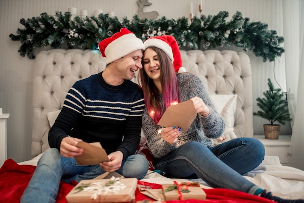 Coppia di avvolgere i regali di Natale, a casa. Scatola artigianale natalizia.