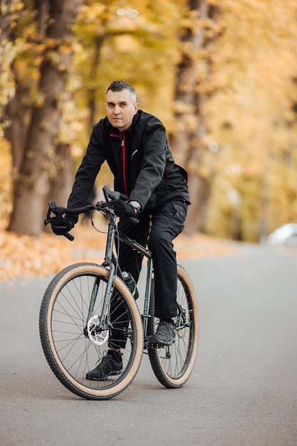 Coppia di ciclisti di montagna su una pista ciclabile nella foresta autunnale Ciclismo di montagna nella foresta paesaggistica autunnale