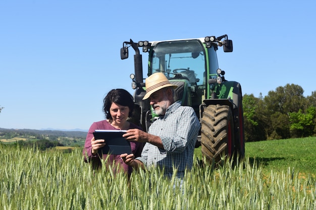 Coppia di contadini in un campo con una tavoletta digitale