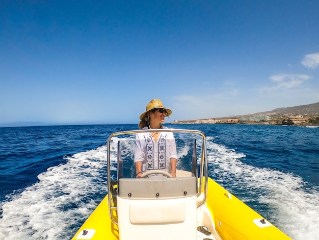 Coppia di due anziani felici e persone mature che usano e guidano una piccola barca o un gommone