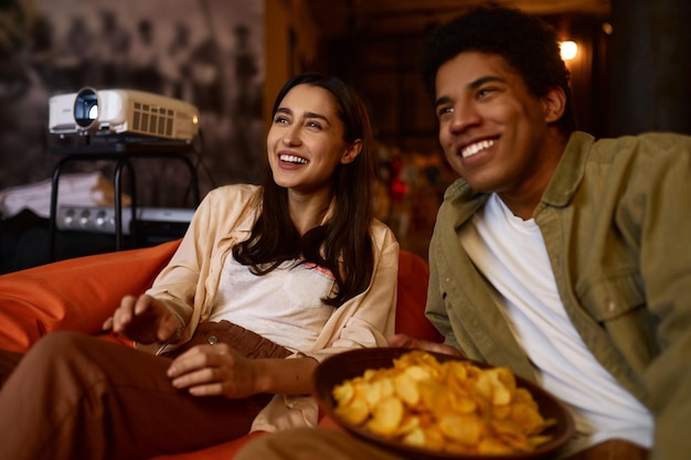 Coppia di famiglia che guarda il proiettore televisivo a casa