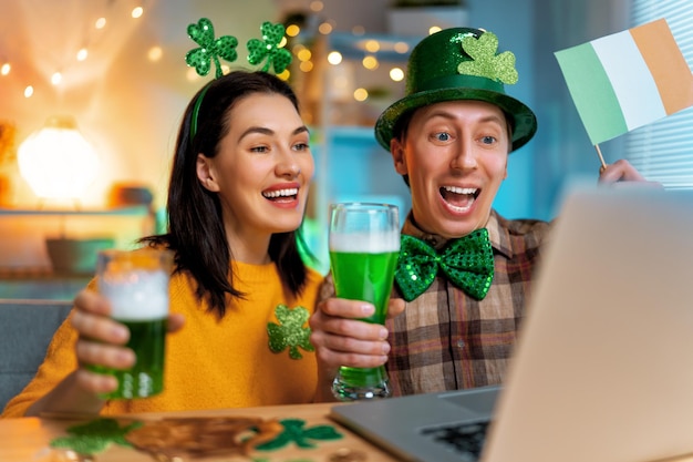 Coppia di famiglia felice che celebra il giorno di San Patrizio con i loro amici online a casa.