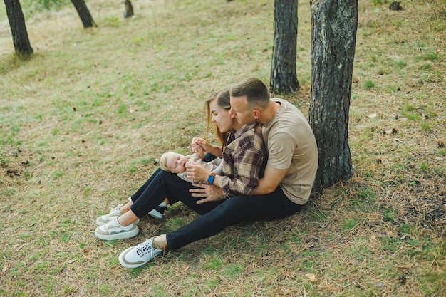 Coppia di famiglia felice con un figlio appena nato in natura Giovane madre e padre felici con un bambino in una passeggiata nella foresta Il concetto di una coppia sposata felice con un bambino