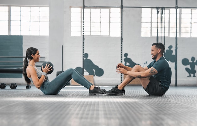 Coppia di fitness sportivo attivo o partner in palestra che si allenano insieme facendo esercizi di base con attrezzature pesanti Allenatore maschio e atleta femminile che si divertono con una sessione di allenamento o una lezione per aumentare la forza