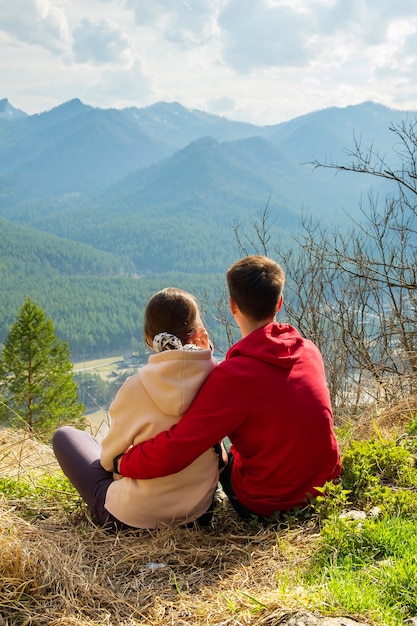 Coppia di giovani viaggiatori che riposano in montagna uomo e donna che fanno un'escursione con gli zaini