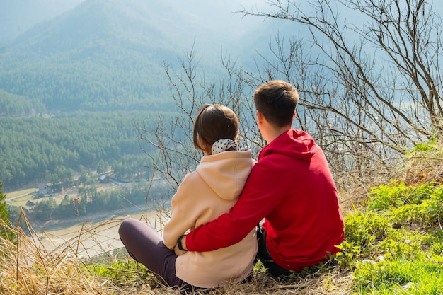 Coppia di giovani viaggiatori che riposano in montagna uomo e donna che fanno un'escursione con gli zaini