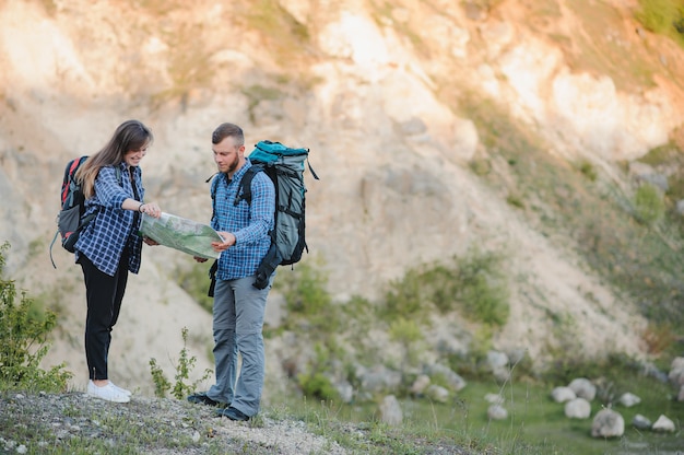 Coppia di giovani viaggiatori felici che fanno un'escursione con gli zaini