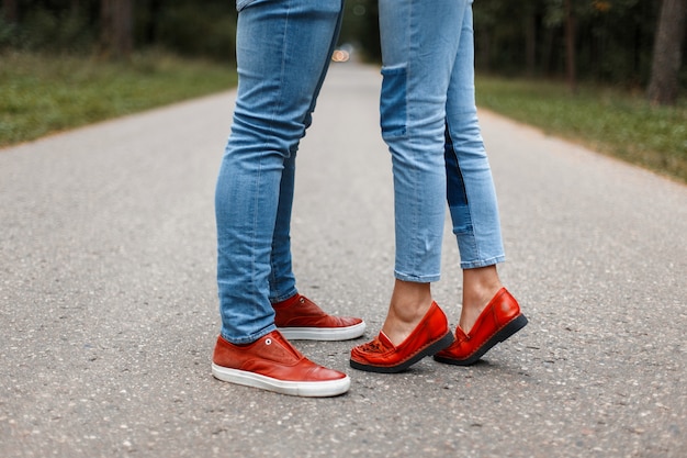 Coppia di innamorati baci sulla strada. Piedini maschili e femminili in scarpe alla moda sull'asfalto