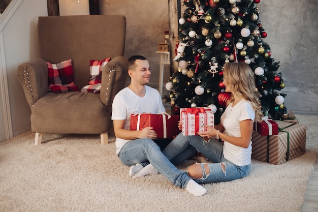 Coppia di innamorati che ordina i regali dall'albero di Natale