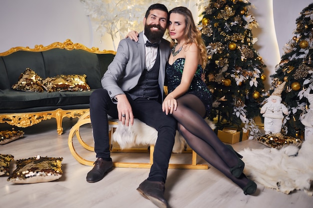Coppia di innamorati in abbigliamento festivo a una vigilia di Natale Capodanno, sorridendo e divertendosi tra loro