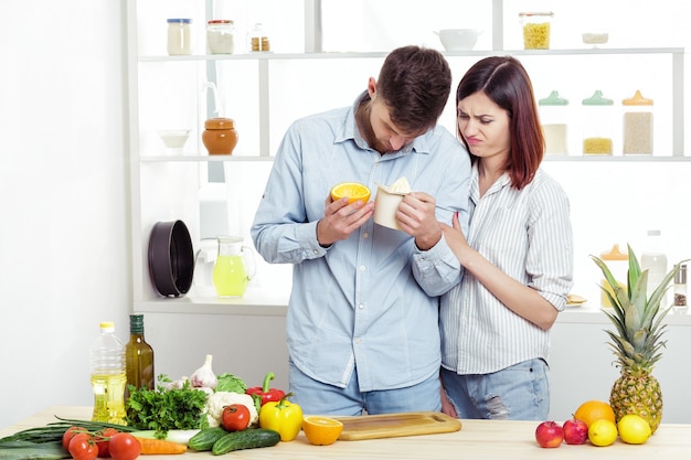 Coppia di innamorati in cucina prepara a mano un sano succo di arancia fresca. Poco succo