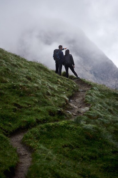 Coppia di innamorati in piedi sulla strada di montagna erbosa