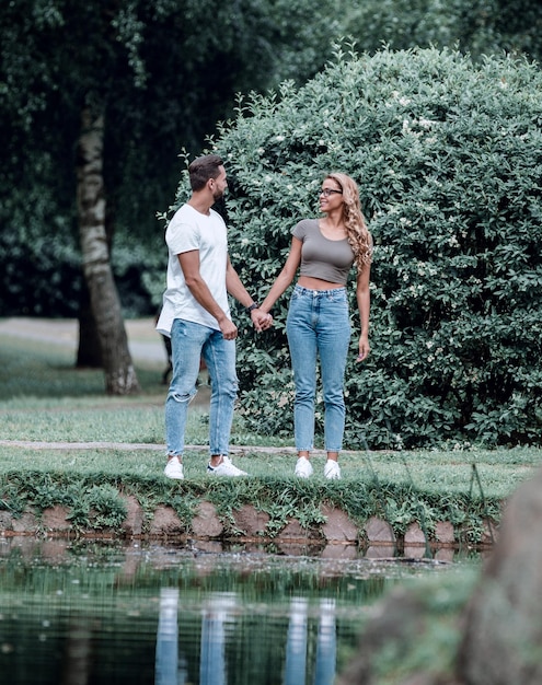 Coppia di innamorati in piedi vicino a un lago in un parco cittadino