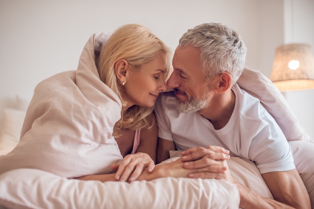 Coppia di mezza età che ha momento romantico in camera da letto