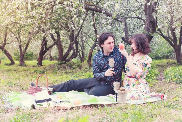 Coppia di paesaggi primaverili innamorati picnic all'aperto sull'albero