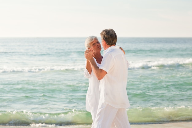 Coppia di pensionati che ballano sulla spiaggia