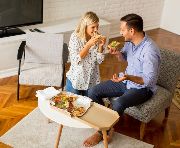 Coppia di relax a casa e mangiare la pizza di buon gusto