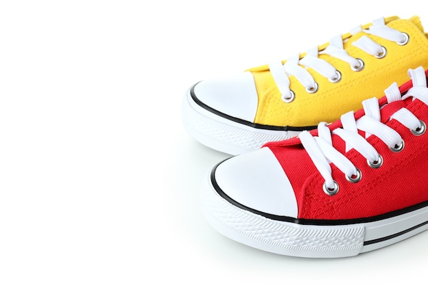 Coppia di scarpe da ginnastica rosse e gialle isolate su sfondo bianco
