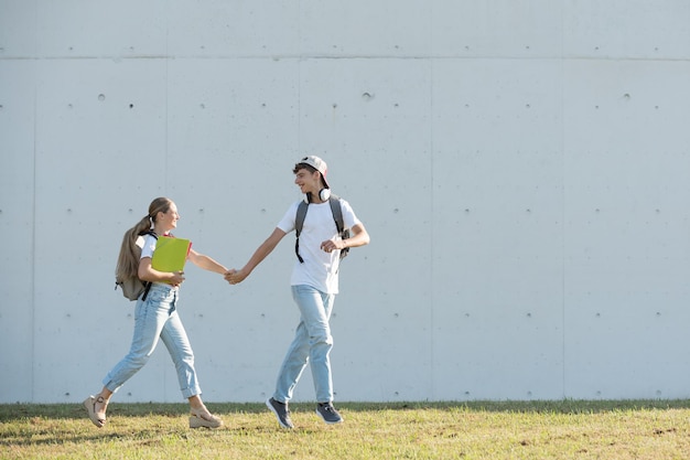 Coppia di studenti in esecuzione tenendosi per mano