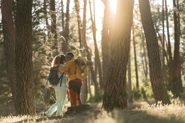 coppia di trekking bacio multirazziale al tramonto della foresta