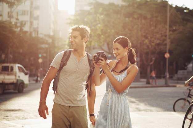 Coppia di turisti e fotografia in strada per viaggiare visite turistiche e felicità in vacanza o vacanza in Brasile Camera uomo e donna con sorriso in strada in città per esplorare il turismo o il viaggio in città