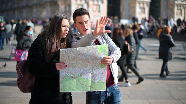 Coppia di turisti in città guardando una mappa e discutendo della prossima destinazione