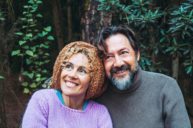 Coppia di turisti uomo e donna sorridono e godono di un ritratto con la foresta di foglie verdi sullo sfondo Concetto di persone e natura Stile di vita e amore di viaggio Relazione e amicizia Mezza età