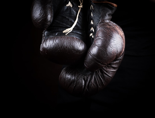 Coppia di vecchi guantoni da boxe marroni appesi