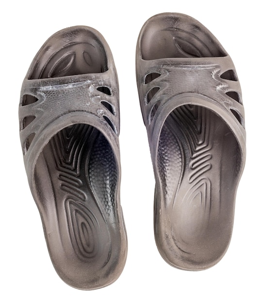 Coppia di vecchie pantofole di gomma nere isolate su sfondo bianco vista dall'alto