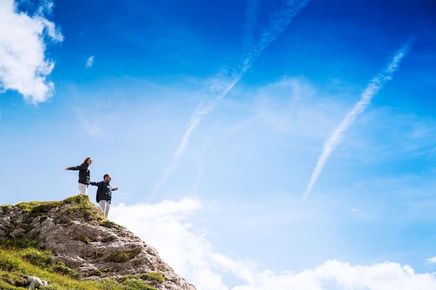 Coppia di viaggiatori escursionisti in cima a una montagna che si gode la vista sulla valle Concetto di vacanze di viaggio