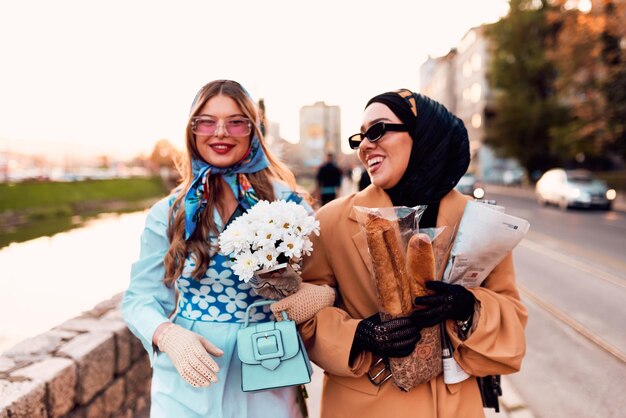 Coppia donna che indossa un hijab e un abito moderno ma tradizionale e l'altra con un abito blu