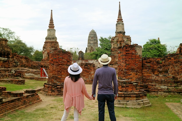 Coppia essere impressionato dalle rovine impressionanti del tempio nel parco storico di Ayutthaya, Tailandia