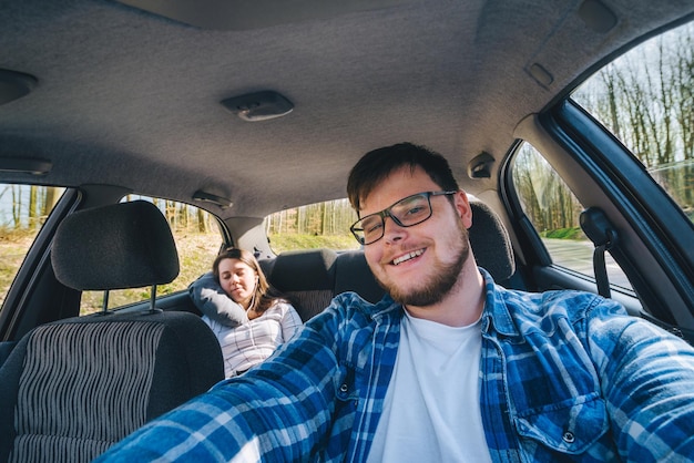 Coppia facendo selfie in auto. concetto di viaggio in auto.