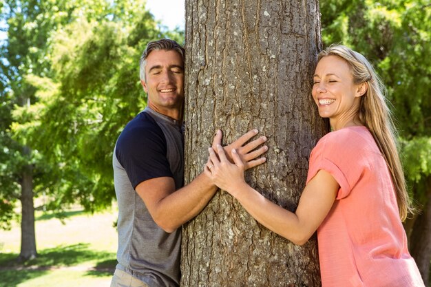 Coppia felice abbracciando un albero