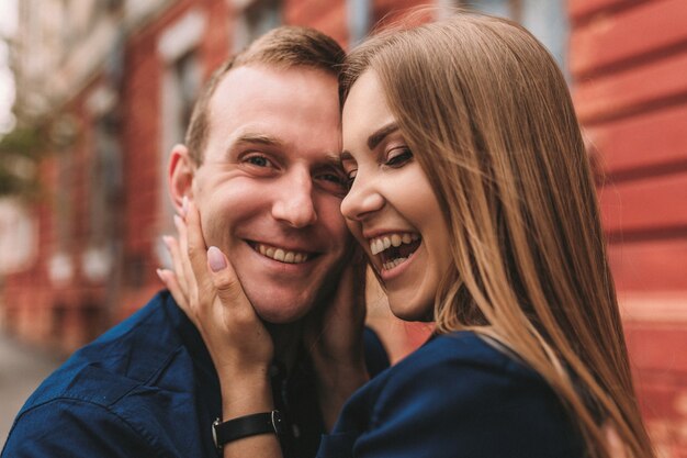 Coppia felice che abbraccia e sorride. Ritratto di un ragazzo e una ragazza con un sorriso sui loro volti.